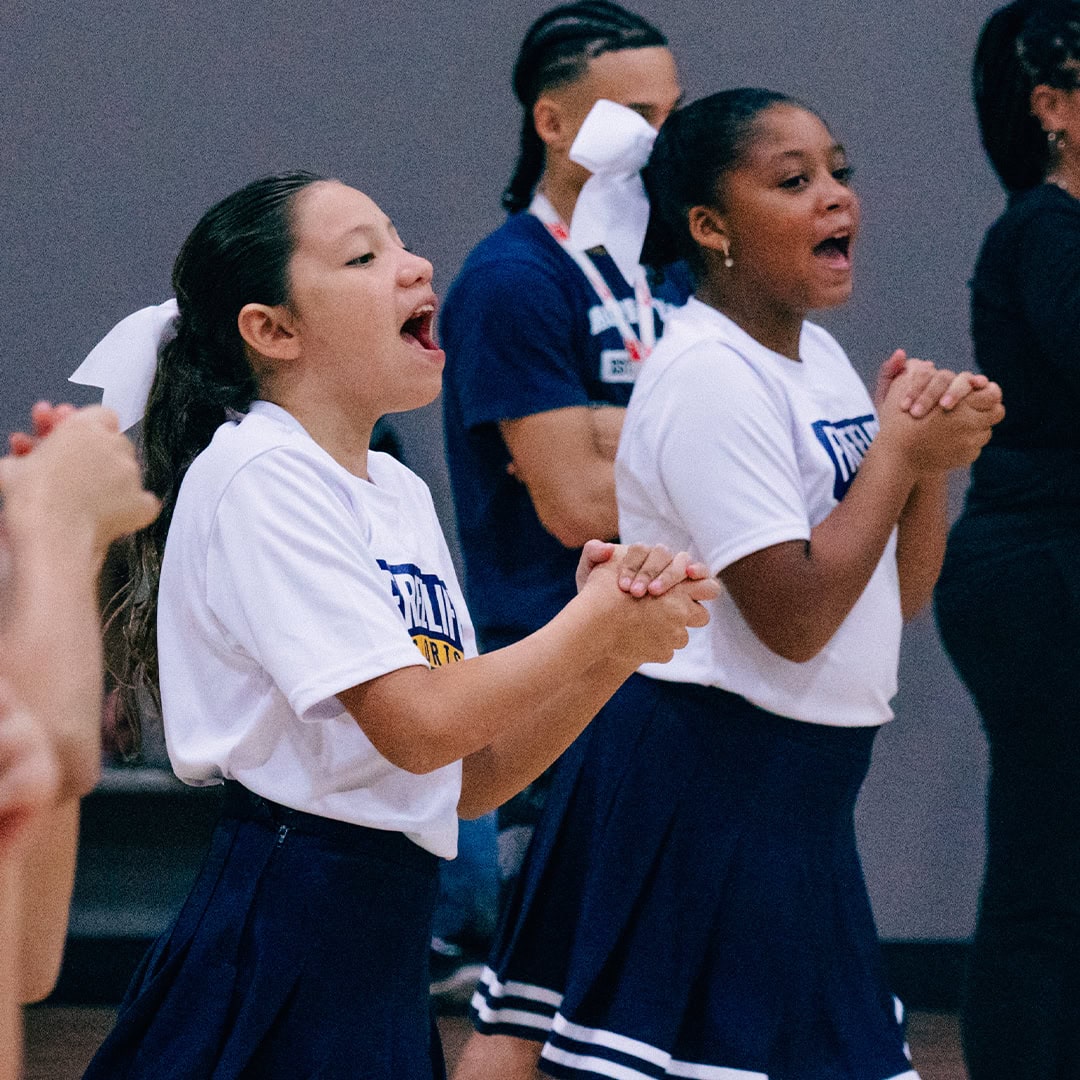 Basketball & Cheer Season - girl cheerleaders doing a routine during a game